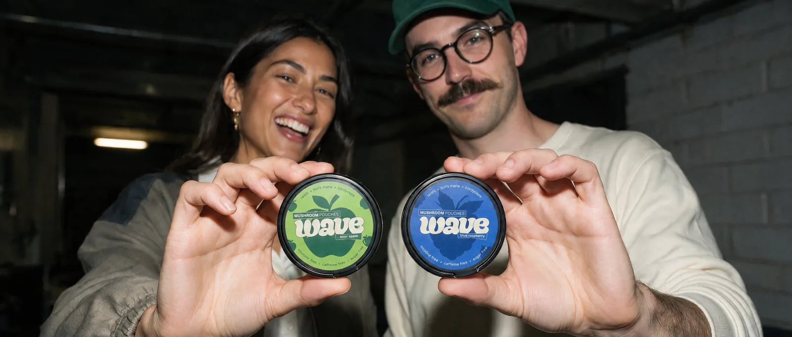 Zwei Personen halten WAVE-Dosen: Sour Apple und Blue Raspberry.